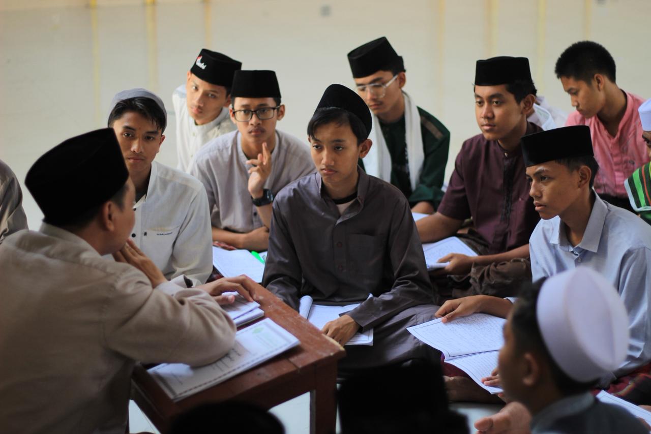 Student studying Islamic books in library